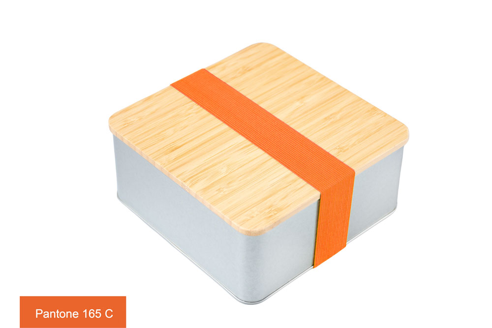 Geschlossene quadratische Blechdose mit Bambusdeckel und orangefarbenem Farbband (Pantone 165 C), auf weißem Hintergrund fotografiert.