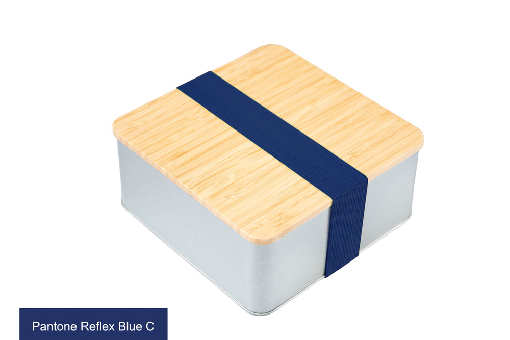 Quadratische Blechdose mit Bambusdeckel und blauem elastischem Band (Pantone Reflex Blue C) als Verschluss, auf weißem Hintergrund fotografiert.