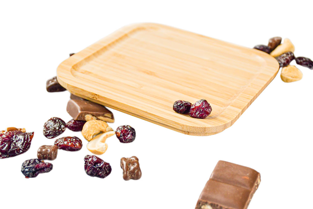 Seitenansicht quadratischer Bambusdeckel neben getrockneten Früchten – Ersatzteil für Lunchbox.
