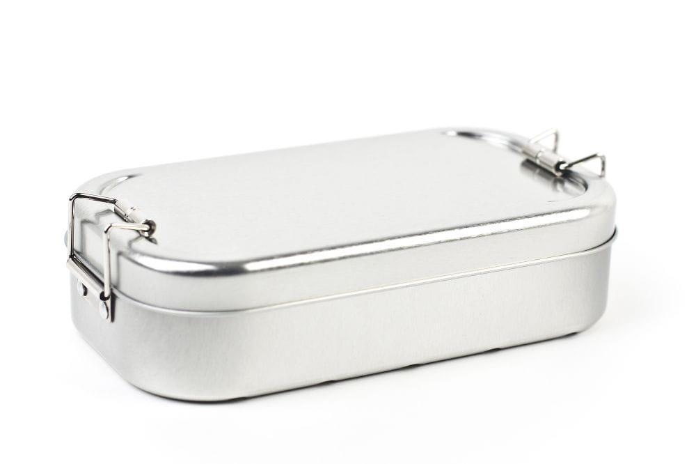 Geschlossene rechteckige Lunchbox aus silberfarbenem Edelstahl mit aufgesetztem Deckel und seitlichen Clipverschlüssen, auf weißem Hintergrund fotografiert.